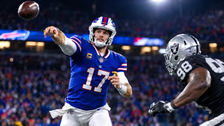 NFL scores today Sunday — Buffalo Bills quarterback throwing under stadium lights during the 33-30 win over the Las Vegas Raiders
